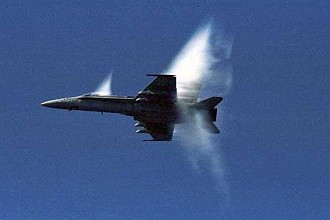 7. An F/A-18 Hornet Fighter Jet, United States Navy, Off the Coast of Nippon-koku (Nihon-koku) - Japan, Sea of Japan. Reaching the sound barrier, breaking the sound barrier: Flying at transonic speeds (flying transonically) -- speeds varying near and at the speed of sound (supersonic) -- can generate impressive condensation clouds caused by the Prandtl-Glauert Singularity. For a scientific explanation, see Professor M. S. Cramer's Gallery of Fluid Mechanics, Prandtl-Glauert Singularity at <http://www.GalleryOfFluidMechanics.com/conden/pg_sing.htm>; and Foundations of Fluid Mechanics, Navier-Stokes Equations Potential Flows: Prandtl-Glauert Similarity Laws at <http://www.Navier-Stokes.net/nspfsim.htm>. Photo Credit: Seventh Fleet - Photos (http://www.c7f.navy.mil/images.html, November 12, Sea of Japan), Commander, U.S. Seventh Fleet (http://www.c7f.navy.mil), United States Navy (USN, http://www.navy.mil), United States Department of Defense (DoD, http://www.DefenseLink.mil or http://www.dod.gov), Government of the United States of America (USA).