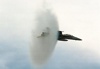 8. An F/A-18E Super Hornet Fighter Jet, United States Navy, Off the Coast of Southern California, United States. Reaching the sound barrier, breaking the sound barrier: Flying at transonic speeds (flying transonically) -- speeds varying near and at the speed of sound (supersonic) -- can generate impressive condensation clouds caused by the Prandtl-Glauert Singularity. For a scientific explanation, see Professor M. S. Cramer's Gallery of Fluid Mechanics, Prandtl-Glauert Singularity at <http://www.GalleryOfFluidMechanics.com/conden/pg_sing.htm>; and Foundations of Fluid Mechanics, Navier-Stokes Equations Potential Flows: Prandtl-Glauert Similarity Laws at <http://www.Navier-Stokes.net/nspfsim.htm>. Photo Credit: PHAA Jeremie Kerns, USS Carl Vinson (CVN 70) Photo Gallery (http://www.vinson.navy.mil/photos/oct00.html, October 2000, 'VFA-122 experts breaking the sound barrier in the F/A 18E at the end of FRS CQs onboard USS Carl Vinson off the coast of southern California.'), USS Carl Vinson (CVN 70) (http://www.vinson.navy.mil), United States Navy (USN, http://www.navy.mil), United States Department of Defense (DoD, http://www.DefenseLink.mil or http://www.dod.gov), Government of the United States of America (USA).