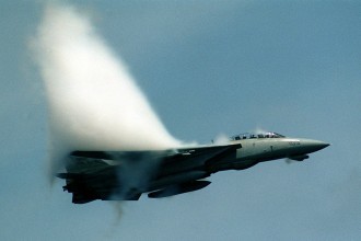 10. An F-14D 'Super Tomcat' Fighter Jet With the Fighter Squadron Two (VF-2), July 10, 1999, USS Constellation (CV 64), United States Navy. Reaching the sound barrier, breaking the sound barrier: Flying at transonic speeds (flying transonically) -- speeds varying near and at the speed of sound (supersonic) -- can generate impressive condensation clouds caused by the Prandtl-Glauert Singularity. For a scientific explanation, see Professor M. S. Cramer's Gallery of Fluid Mechanics, Prandtl-Glauert Singularity at <http://www.GalleryOfFluidMechanics.com/conden/pg_sing.htm>; and Foundations of Fluid Mechanics, Navier-Stokes Equations Potential Flows: Prandtl-Glauert Similarity Laws at <http://www.Navier-Stokes.net/nspfsim.htm>. Photo Credit: Ensign John Gay, Image ID: 990710-N-6483G-001, Expeditionary Warfare Division (N75) in the Office of the Chief of Naval Operations, United States Navy (USN, http://www.navy.mil), United States Department of Defense (DoD, http://www.DefenseLink.mil or http://www.dod.gov), Government of the United States of America (USA).