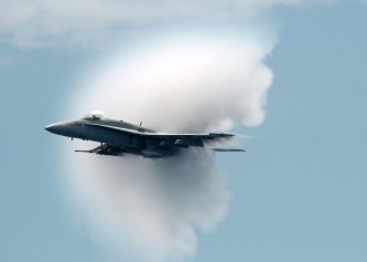 13. An F/A-18C Hornet Fighter Jet Assigned to the 'Golden Dragons' of Strike Fighter Squadron One Nine Two (VFA-192). August 17, 2005, Pacific Ocean. Reaching the sound barrier, breaking the sound barrier: Flying at transonic speeds (flying transonically) -- speeds varying near and at the speed of sound (supersonic) -- can generate impressive condensation clouds caused by the Prandtl-Glauert Singularity. For a scientific explanation, see Professor M. S. Cramer's Gallery of Fluid Mechanics, Prandtl-Glauert Singularity at <http://www.GalleryOfFluidMechanics.com/conden/pg_sing.htm>; and Foundations of Fluid Mechanics, Navier-Stokes Equations Potential Flows: Prandtl-Glauert Similarity Laws at <http://www.Navier-Stokes.net/nspfsim.htm>. Photo Credit: Photographer's Mate 3rd Class Jonathan Chandler, Navy NewsStand - Eye on the Fleet Photo Gallery (http://www.news.navy.mil/view_photos.asp, 050817-N-3488C-151), United States Navy (USN, http://www.navy.mil), United States Department of Defense (DoD, http://www.DefenseLink.mil or http://www.dod.gov), Government of the United States of America (USA). See the companion photo in 'An F/A-18C Hornet conducts a high-speed pass prior to breaking the speed of sound.' at <http://www.news.navy.mil/view_single.asp?id=27228>.