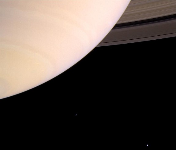 Saturn's Atmosphere, the Rings (upper right), and Two Moons, Mimas and Enceladus (lower right) Photo Credit: Cassini-Huygens Mission (http://saturn.jpl.nasa.gov), Cassini Orbiter, August 8, 2004; National Aeronautics and Space Administration (NASA, http://www.nasa.gov)/Jet Propulsion Laboratory (JPL, http://www.jpl.nasa.gov), Government of the United States of America.