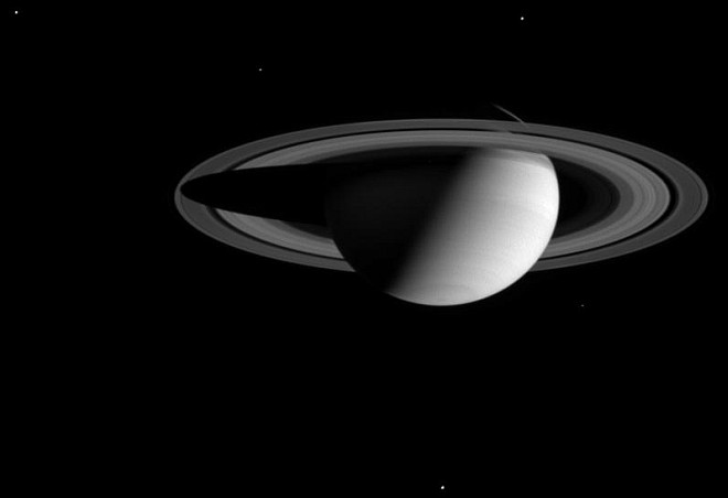 Thick Darkness Surrounds Saturn and Five Visible Moons (clockwise from upper left: Dione, Enceladus, Tethys, Mimas, and Rhea). Photo Credit: Cassini-Huygens Mission (http://saturn.jpl.nasa.gov), Cassini Orbiter, August 1, 2004; Planetary Photojournal (http://photojournal.jpl.nasa.gov, PIA06475), National Aeronautics and Space Administration (NASA, http://www.nasa.gov)/Jet Propulsion Laboratory (JPL, http://www.jpl.nasa.gov)/Space Science Institute (http://ciclops.org), Government of the United States of America.