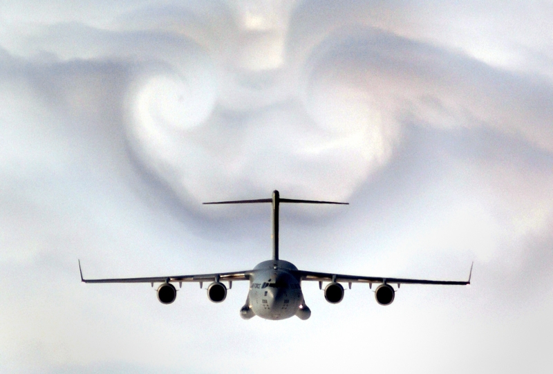 The United States Air Force C-17 Globemaster III Military Transport Parts the Western South Carolina Clouds Causing an Impressive Corridor-in-the-Clouds and Cloud Formations, February 2, 2003. State of South Carolina, USA. Photo Credit: Staff Sgt. D. Myles Cullen, 1st Combat Camera Squadron, Air Force Link - Photos (http://www.af.mil/photos, 030202-F-0193C-004, "Parting clouds"), United States Air Force (USAF, http://www.af.mil), United States Department of Defense (DoD, http://www.DefenseLink.mil or http://www.dod.gov), Government of the United States of America (USA). C-17 Globemaster III fact sheets from the United States Air Force <http://www.af.mil/factsheets/factsheet.asp?fsID=86> and The Boeing Company <http://www.boeing.com/defense-space/military/c17/index.htm>.