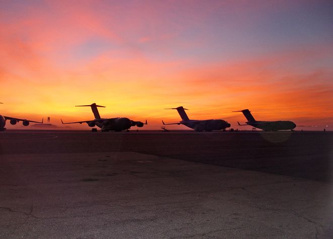 A Beautiful Sunrise Reveals and the Morning Fog Cannot Hide the United States Air Force C-17 Globemaster III Military Transport Aircraft Lining the Runway on January 5, 2005. Charleston Air Force Base, State of South Carolina, USA. Photo Credit: Tech. Sgt. Russell Gardner, Air Force Link - Week in Photos, January 14, 2005 (http://www.af.mil/weekinphotos/050114-01.html, 050105-F-0000G-001, By the dawn's early light), United States Air Force (USAF, http://www.af.mil), United States Department of Defense (DoD, http://www.DefenseLink.mil or http://www.dod.gov), Government of the United States of America (USA).