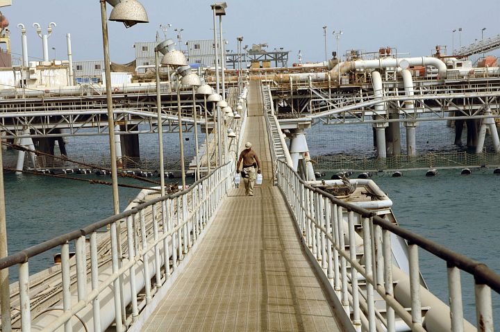 Walking Alone On Bridge (or Walkway) That Spans a Portion of the North Persian Gulf's Flowing Waters to Bring Needed Bottled Water (H20), June 12, 2005. Al Basrah Oil Terminal, Basra, Al Jumhuriyah al Iraqiyah - Republic of Iraq. Photo Credit: Photographer's Mate 1st Class Aaron Ansarov, Navy NewsStand - Eye on the Fleet Photo Gallery (http://www.news.navy.mil/view_photos.asp, 050612-N-4309A-350), United States Navy (USN, http://www.navy.mil); United States Department of Defense (DoD, http://www.DefenseLink.mil or http://www.dod.gov), Government of the United States of America (USA).