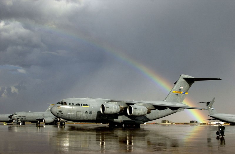 A Beautiful, Partially Very Bright Rainbow -- an Arc of Light -- Effortlessly Cuts Through a Dark Sky Full of Grey Clouds After a Sudden and Heavy Rain Shower, Arching Over the Airfield at Moron Air Base, January 2003, Reino de Espaa - Kingdom of Spain. Photo Credit: Staff Sgt. P. J. Farlin, Air Force Link - Photos (http://www.af.mil/photos, 030128-O-9999J-023, "Rainbow After Rain"), United States Air Force (USAF, http://www.af.mil), United States Department of Defense (DoD, http://www.DefenseLink.mil or http://www.dod.gov), Government of the United States of America (USA).