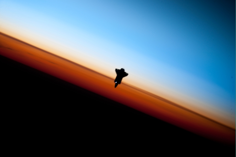 37. Orbital Sunset: Striking View of Earth's Colorful Horizon and the Silhouette of Space Shuttle Endeavour (STS-130), February 9, 2010, As Seen From the International Space Station (Expedition Twenty-Two) While Orbiting Above the South Pacific Ocean Off the Coast of Southern Chile: Latitude (LAT): -46.9, Longitude (LON): -80.5, Altitude (ALT): 183 Nautical Miles. Photo Credit: STS-130 Shuttle Mission Imagery (http://spaceflight.nasa.gov/gallery/images/shuttle/sts-130/ndxpage1.html), ISS022-E-062674 (http://spaceflight.nasa.gov/gallery/images/shuttle/sts-130/html/iss022e062674.html), NASA Human Space Flight (http://spaceflight.nasa.gov), National Aeronautics and Space Administration (NASA, http://www.nasa.gov), Government of the United States of America. More details from NASA: 'The orange layer is the troposphere, where all of the weather and clouds which we typically watch and experience are generated and contained. This orange layer gives way to the whitish Stratosphere and then into the Mesosphere. In some frames the black color is part of a window frame rather than the blackness of space.'
