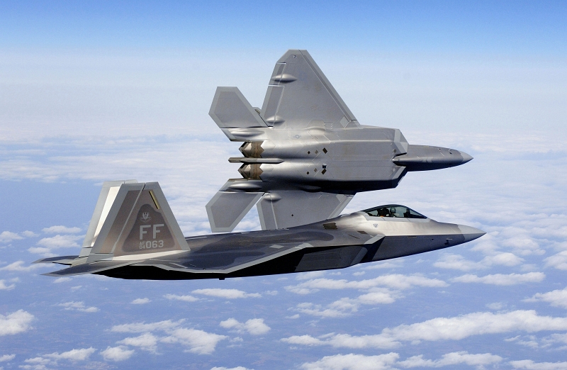 42. New U.S. Air Force F-22A Raptor Stealth Fighter Jets Fly Over the Continental United States of America, March 3, 2006. Photo Credit: Tech. Sgt. Ben Bloker, United States Air Force; Defense Visual Information (DVI, http://www.DefenseImagery.mil, 060303-F-2295B-035 and DF-SD-07-04380) and United States Air Force (USAF, http://www.af.mil), United States Department of Defense (DoD, http://www.DefenseLink.mil or http://www.dod.gov), Government of the United States of America (USA). Full description: 'US Air Force (USAF) Lieutenant Colonel (LTC) Dirk Smith, Commander, 94th Fighter Squadron (FS), peels away from USAF Major (MAJ) Kevin Dolata, Assistant Director of Operations, 94th FS, during the delivery flight of the first F/A-22A Raptor fighters to the 94th FS at Langley Air Force Base (AFB), Virginia (VA). The 94th FS is the second squadron at Langley to receive the new stealth fighter.'