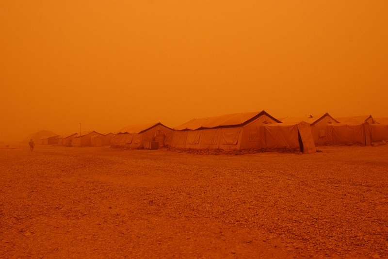 1. The Strong, Dry Desert Wind Blows Huge Clouds of Sand Creating a Hovering Sandstorm Which Changes the Color of the Entire Area, Including the Sky, Into a Surreal Orange Color (Tints of Orange), May 5, 2005, Tallil Air Base, Al Jumhuriyah al Iraqiyah - Republic of Iraq. Photo Credit: Staff Sgt. Darcie Ibidapo, United States Air Force (USAF, http://www.af.mil); DefenseLINK News Photos (http://www.DefenseLink.mil/photos/, 050505-F-4903I-191), United States Department of Defense (DoD, http://www.DefenseLink.mil or http://www.dod.gov), Government of the United States of America (USA).