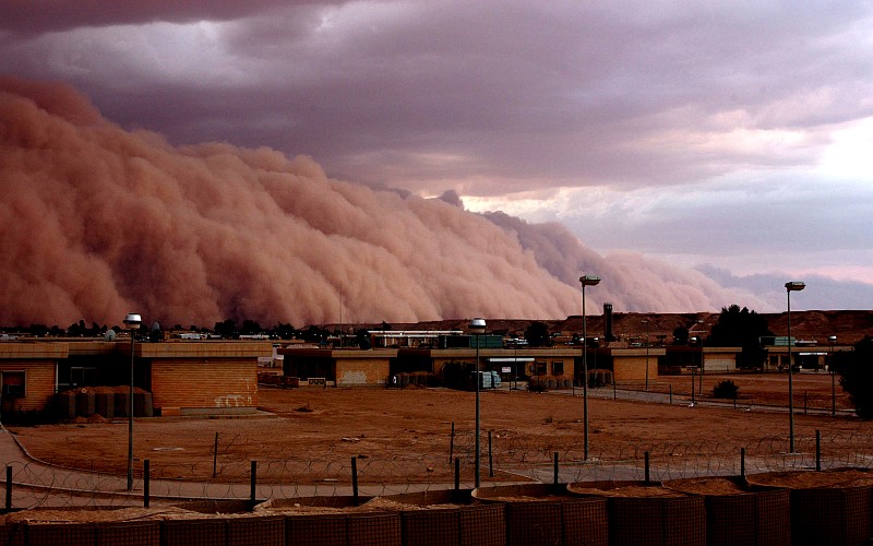 9. The Long, Huge, Rolling Mountain of Sand is a Sandstorm 4,000 to 5,000 Feet High, and It Appears to Touch the Clouds In the Sky Above, April 26, 2005, Al Asad, Al Anbar Province, Al Jumhuriyah al Iraqiyah - Republic of Iraq. Photo Credit: Gunnery Sgt. Shannon Arledge, 2nd Marine Aircraft Wing, United States Marine Corps (USMC, http://www.usmc.mil); 'DefendAmerica - U.S. Defense Dept. War on Terror: 04/26/2005 - Edition 7, STORMY WEATHER' (http://www.DefendAmerica.mil/archive/2005-04/20050426pm4.html, http://www.DefendAmerica.mil), Photo ID: 20050426-M-0502A-017, United States Department of Defense (DoD, http://www.DefenseLink.mil or http://www.dod.gov), Government of the United States of America (USA). See the Marine Corps News story 'Dust in the wind: A wall of sand moves through Al Asad' by USMC Gunnery Sgt. Shannon Arledge, 2nd Marine Aircraft Wing, April 26, 2005 (Story ID#: 2005426134811, http://www.usmc.mil/marinelink/mcn2000.nsf/lookupstoryref/2005426134811).