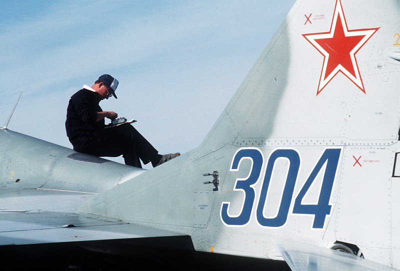 5. A USSR Technician Works While Sitting On Top of the Soviet MiG-29 Fighter (Tail Number 304) as the Aircraft Is Refueled, August 1989, Elmendorf Air Force Base, State of Alaska, USA. Photo Credit: SSgt. Kevin L. Bishop, United States Air Force (USAF, http://www.af.mil); Defense Visual Information Center (DVIC, http://www.DoDMedia.osd.mil, DFST9005762) and United States Air Force (USAF, http://www.af.mil), United States Department of Defense (DoD, http://www.DefenseLink.mil or http://www.dod.gov), Government of the United States of America (USA).