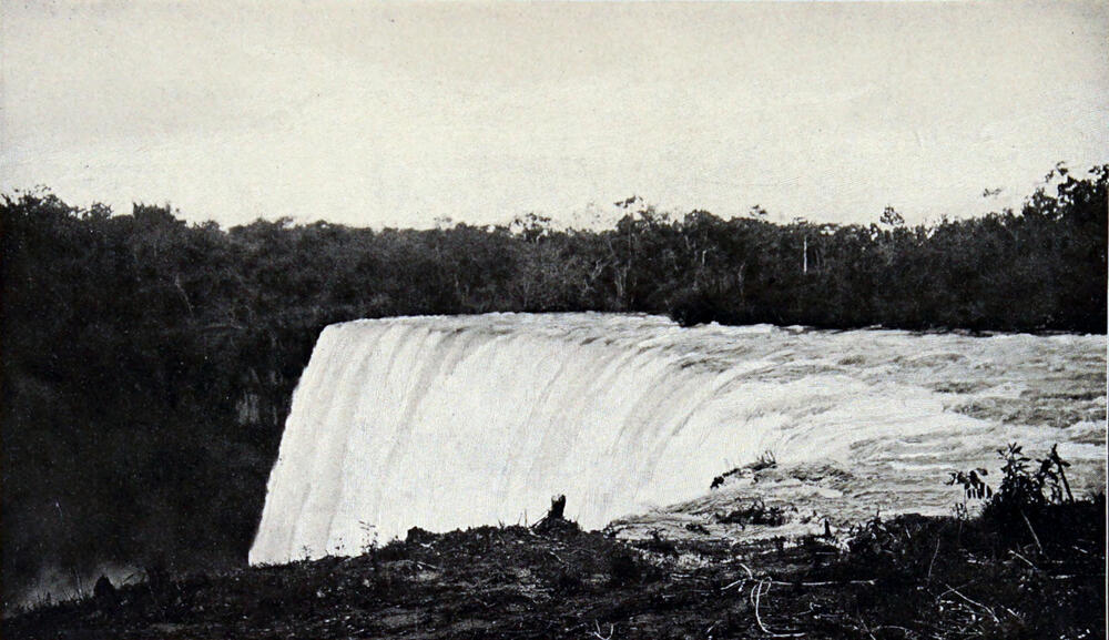 A photograph of a huge waterfall, with riverbanks on either side of it.
