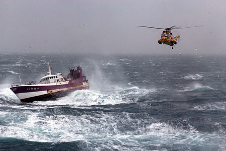 A Sea King rescue helicopter of the UK Royal Navy assists French fishing vessel 'Alf' in the Irish Sea.
