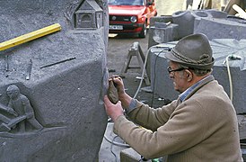 Sculptor Paul Milles copying an original hand ax on a history stone
