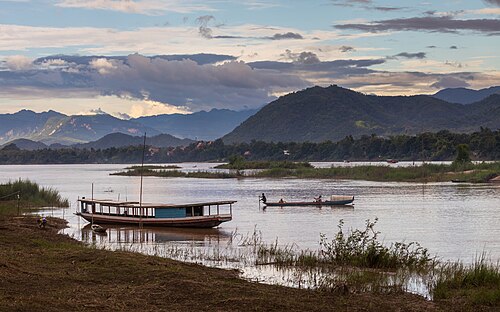 Pirogue and boat on the Mekong with colorful sky at sunset in Luang Prabang Laos