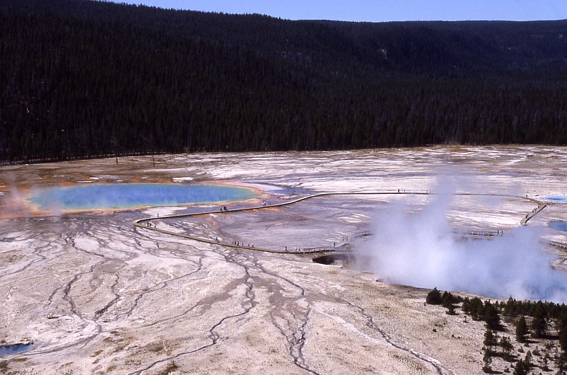4. Photograph From 1987 of the Grand Prismatic Spring, Midway Geyser Basin, Yellowstone National Park, State of Wyoming, USA. Photo Credit: NPS Photo, Ed Austin and Herb Jones, 1987. Yellowstone Digital Slide File - Midway & Lower Geyser Basin (http://www.nps.gov/archive/yell/slidefile/index.htm and http://www.nps.gov/archive/yell/slidefile/thermalfeatures/hotspringsterraces/midwaylower/Page.htm, Image 13402), Yellowstone National Park (http://www.nps.gov/yell), National Park Service (NPS, http://www.nps.gov), United States Department of the Interior (http://www.doi.gov), Government of the United States of America (USA).