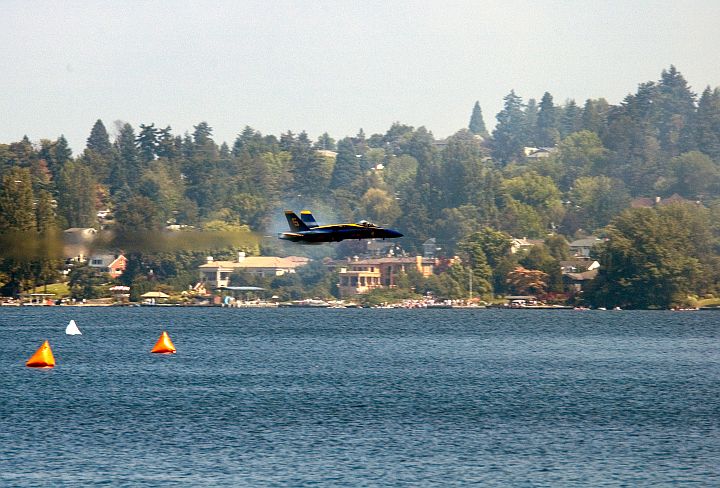 August 6, 2005, SEAFAIR 2005 KeyBank Air Show, Seattle, State of Washington, USA: The Scenic View of the Tree-Covered Landscape Overlooking Lake Washington is Enhanced by the Prandtl-Glauert Cloud Around a Low Flying and Transonic U.S. Navy Blue Angels F/A-18A Hornet Fighter Jet. Photo Credit: Photographer's Mate 3rd Class Douglas G. Morrison, Navy NewsStand - Eye on the Fleet Photo Gallery (http://www.news.navy.mil/view_photos.asp, 050806-N-3390M-019), United States Navy (USN, http://www.navy.mil), United States Department of Defense (DoD, http://www.DefenseLink.mil or http://www.dod.gov), Government of the United States of America (USA). Flying within the transonic regime -- speeds varying near and at the speed of sound (supersonic) -- can generate impressive condensation clouds caused by the Prandtl-Glauert Singularity. For a scientific explanation, see Dr. Mark. S. Cramer's Gallery of Fluid Mechanics, Prandtl-Glauert Singularity at <http://www.GalleryOfFluidMechanics.com/conden/pg_sing.htm>; the Prandtl-Glauert Condensation Clouds tutorial at <http://FluidMech.net/tutorials/sonic/prandtl-glauert-clouds.htm>; and Foundations of Fluid Mechanics, Navier-Stokes Equations Potential Flows: Prandtl-Glauert Similarity Laws at <http://www.Navier-Stokes.net/nspfsim.htm>.