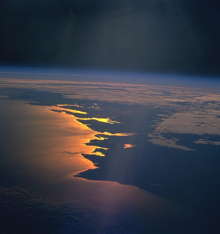 Space Shuttle Columbia (STS-93), July 26, 1999, 03:40:43 UTC: Planet Earth's Beautiful Sunrise -- Reflected Light In Glowing Shades of Gold, Yellow and Orange -- on the Mozambique Channel Along the Coast of Republique de Madagascar - Republic of Madagascar. Photo Credit: NASA's Space Shuttle Columbia: STS-93 Mission; NASA-Johnson Space Center. 'Astronaut Photography of Earth - Display Record.' <http://eol.jsc.nasa.gov/scripts/sseop/photo.pl?mission=STS093&roll=716&frame=65>; National Aeronautics and Space Administration (NASA, http://www.nasa.gov), Government of the United States of America (USA). The photo's full size request URL is <http://eol.jsc.nasa.gov/scripts/sseop/LargeImageAccess.pl?directory=ISD/highres/STS093&filename=STS093-716-65_4.JPG&filesize=1341594>