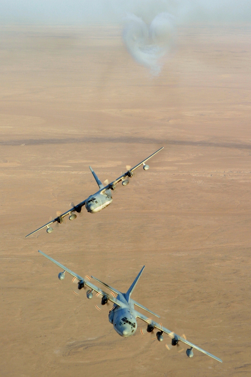 4. Aerial View of Two United States Marine Corps KC-130 Hercules Aircraft, Assigned to Marine Aerial Refueler-Transport Squadron Two Thirty Four (VMGR-234), Executing Trial Evasive Maneuvers After Firing Flares Used to Counter an Attack by Surface to Air Missiles (SAMs or SAM) During Operation Iraqi Freedom, September 4, 2003, Al Jumhuriyah al Iraqiyah - Republic of Iraq. Photo Credit: Lance Cpl. Andrew Z. Williams, United States Marine Corps (USMC, http://www.usmc.mil); Defense Visual Information Center (DVIC, http://www.DoDMedia.osd.mil, DMSD0511419 and 030904M7837W012) and United States Marine Corps (USMC, http://www.usmc.mil), United States Department of Defense (DoD, http://www.DefenseLink.mil or http://www.dod.gov), Government of the United States of America (USA).