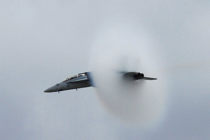 3. An F/A-18F Super Hornet Fighter Jet Assigned to the 'Screaming Eagles' of Strike Fighter Squadron One Two Two (VFA-122), Miramar Air Show, October 15, 2006, Marine Corps Air Station Miramar, San Diego, State of California, USA. Flying at transonic speeds (flying transonically) -- speeds varying near and at the speed of sound (supersonic) -- can generate impressive condensation clouds caused by the Prandtl-Glauert Singularity. For a scientific explanation, see Professor M. S. Cramer's Gallery of Fluid Mechanics, Prandtl-Glauert Singularity at <http://www.GalleryOfFluidMechanics.com/conden/pg_sing.htm>; and Foundations of Fluid Mechanics, Navier-Stokes Equations Potential Flows: Prandtl-Glauert Similarity Laws at <http://www.Navier-Stokes.net/nspfsim.htm>. Photo Credit: Mass Communication Specialist 2nd Class Scott Taylor, Navy NewsStand - Eye on the Fleet Photo Gallery (http://www.news.navy.mil/view_photos.asp, 061015-N-9500T-008), United States Navy (USN, http://www.navy.mil), United States Department of Defense (DoD, http://www.DefenseLink.mil or http://www.dod.gov), Government of the United States of America (USA).