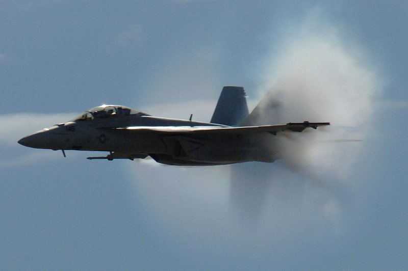 4. An F/A-18F Super Hornet Fighter Jet Assigned to the 'Screaming Eagles' of Strike Fighter Squadron One Two Two (VFA-122), Miramar Air Show, October 13, 2006, Marine Corps Air Station Miramar, San Diego, State of California, USA. Flying at transonic speeds (flying transonically) -- speeds varying near and at the speed of sound (supersonic) -- can generate impressive condensation clouds caused by the Prandtl-Glauert Singularity. For a scientific explanation, see Professor M. S. Cramer's Gallery of Fluid Mechanics, Prandtl-Glauert Singularity at <http://www.GalleryOfFluidMechanics.com/conden/pg_sing.htm>; and Foundations of Fluid Mechanics, Navier-Stokes Equations Potential Flows: Prandtl-Glauert Similarity Laws at <http://www.Navier-Stokes.net/nspfsim.htm>. Photo Credit: Mass Communication Specialist 2nd Class Scott Taylor, Navy NewsStand - Eye on the Fleet Photo Gallery (http://www.news.navy.mil/view_photos.asp, 061013-N-9500T-008), United States Navy (USN, http://www.navy.mil), United States Department of Defense (DoD, http://www.DefenseLink.mil or http://www.dod.gov), Government of the United States of America (USA).