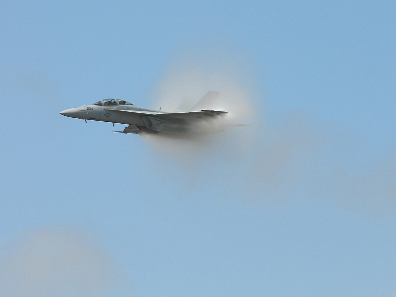 11. A Transonic F/A-18F Super Hornet Fighter Jet Assigned to the 'Checkmates' of Strike Fighter Squadron Two One One (VFA-211), 2007 Naval Air Station Oceana Air Show, Naval Air Station Oceana, September 9, 2007, Virginia Beach, Commonwealth of Virginia, USA. Flying at transonic speeds (flying transonically) -- speeds varying near and at the speed of sound (supersonic) -- can generate impressive condensation clouds caused by the Prandtl-Glauert Singularity. For a scientific explanation, see Professor M. S. Cramer's Gallery of Fluid Mechanics, Prandtl-Glauert Singularity at <http://www.GalleryOfFluidMechanics.com/conden/pg_sing.htm>; and Foundations of Fluid Mechanics, Navier-Stokes Equations Potential Flows: Prandtl-Glauert Similarity Laws at <http://www.Navier-Stokes.net/nspfsim.htm>. Photo Credit: Mass Communication Specialist Seaman Joshua Nuzzo, United States Navy (USN, http://www.navy.mil); Defense Visual Information Center (DVIC, http://www.DoDMedia.osd.mil, 070909-N-4515N-438) and United States Navy (USN, http://www.navy.mil), United States Department of Defense (DoD, http://www.DefenseLink.mil or http://www.dod.gov), Government of the United States of America (USA).