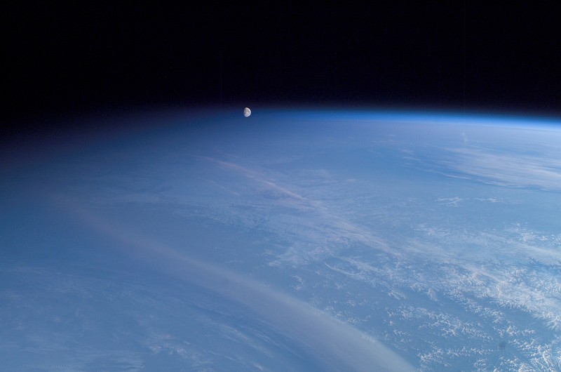 61. It's a Spectacular, Beautiful, and Scenic View of Planet Earth -- Pitch Black Night Approaching From the Left, Moonset Over a Blue Atmosphere Above Earth's Terminator and Horizon, Broad Daylight to the Right Over Cloudly Skies -- On May 11, 2003 at 20:03:04 UTC (GMT) as the International Space Station (Expedition 7) Silently Travels High Above and Across Rossiyskaya Federatsiya - Russian Federation, Latitude (LAT): 51.1, Longitude (LON): 135.2, Altitude (ALT): 204 Nautical Miles, Sun Azimuth (AZI): 69 degrees, Sun Elevation Angle (ELEV): 6 degrees. Photo Credit: ISS007-E-5379, Night to the left, Earth's terminator, Full daylight to the right, Setting of Earth's moon, International Space Station (Expedition Seven) over Russia; Image Science and Analysis Laboratory, NASA-Johnson Space Center. 'Astronaut Photography of Earth - Display Record.' <http://eol.jsc.nasa.gov/scripts/sseop/photo.pl?mission=ISS007&roll=E&frame=5379>; National Aeronautics and Space Administration (NASA, http://www.nasa.gov), Government of the United States of America (USA). In the photo caption <http://eol.jsc.nasa.gov/scripts/sseop/photo.pl?mission=ISS007&roll=E&frame=5379> NASA describes this impressive picture: The moon is really a quarter of a million [250,000] miles away. The picture is tricky because of its uneven lighting. The sun's elevation angle is only 6 [six] degrees. On the left side of the image, night is falling; on the right side, it's still broad daylight. This gradient of sunlight is the key to the illusion.