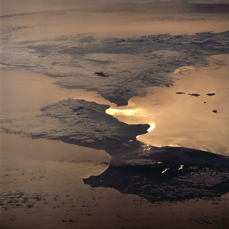 62. The Sun's Late Afternoon Rays Reflect Off the Waters of the Strait of Messina Giving the Appearance of Liquid Gold On February 15, 2001 at 14:36:13 UTC (GMT) -- A Beautiful View Seen From Space Shuttle Atlantis (STS-98) While Over Repubblica Italiana - Italian Republic. Photo Credit: STS098-713-11, Bright sunglint (reflected sunlight) on the Strait of Messina, Space Shuttle Atlantis (STS-98) over Italy; Image Science and Analysis Laboratory, NASA-Johnson Space Center. 'Astronaut Photography of Earth - Display Record.' <http://eol.jsc.nasa.gov/scripts/sseop/photo.pl?mission=STS098&roll=713&frame=11>; National Aeronautics and Space Administration (NASA, http://www.nasa.gov), Government of the United States of America (USA).