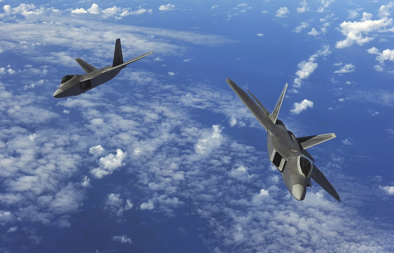 28. Two U.S. Air Force F-22A Raptor Stealth Fighter Jets Fly Over the Western Pacific Ocean, February 16, 2010, Territory of Guam, USA. Photo Credit: Staff Sgt. Jacob N. Bailey, United States Air Force; Defense Visual Information (DVI, http://www.DefenseImagery.mil, 100216-F-5964B-544) and United States Air Force (USAF, http://www.af.mil), United States Department of Defense (DoD, http://www.DefenseLink.mil or http://www.dod.gov), Government of the United States of America (USA).