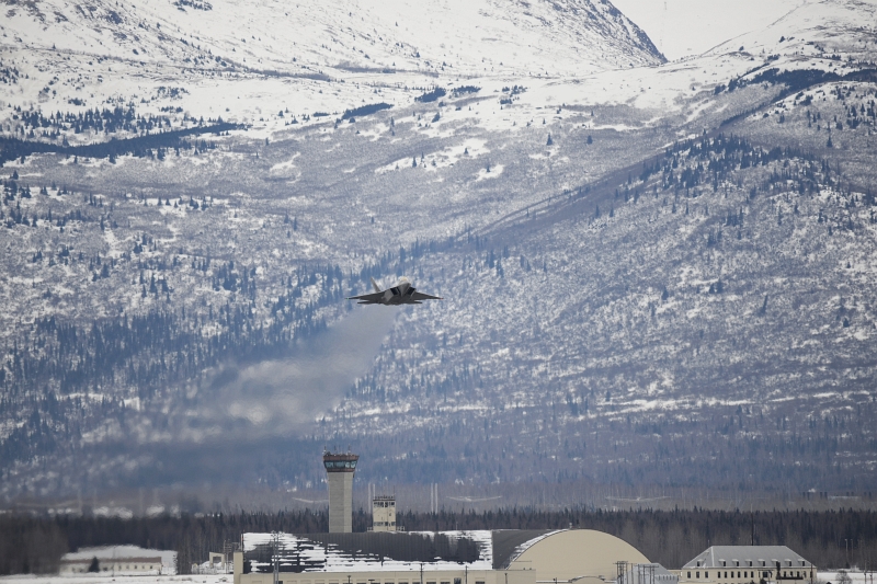 49. Backdropped By Mountains, A U.S. Air Force F-22A Raptor Stealth Fighter Jet Takes Off From Joint Base Elmendorf-Richardson, March 9, 2013, State of Alaska, USA. Photo Credit: TSgt. Dana Rosso, Air Force Link - Photos (http://www.af.mil/photos, 130310-F-PB632-042, 'March UTA'), United States Air Force (USAF, http://www.af.mil), United States Department of Defense (DoD, http://www.DefenseLink.mil or http://www.dod.gov), Government of the United States of America (USA).
