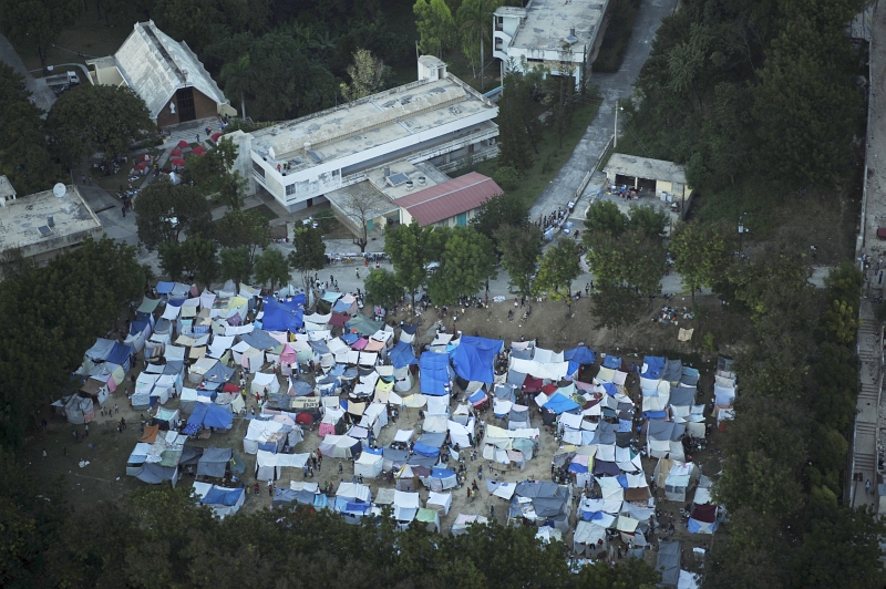 32. Earthquake Survivors At Their Tent Camp, January 15, 2010, Republique d'Haiti (Repiblik d' Ayiti) - Republic of Haiti. Photo Credit: Technical Sgt. (TSgt) James L. Harper Jr., United States Air Force; Defense Visual Information (DVI, http://www.DefenseImagery.mil, 100115-F-4177H-206) and United States Air Force (USAF, http://www.af.mil), United States Department of Defense (DoD, http://www.DefenseLink.mil or http://www.dod.gov), Government of the United States of America (USA).