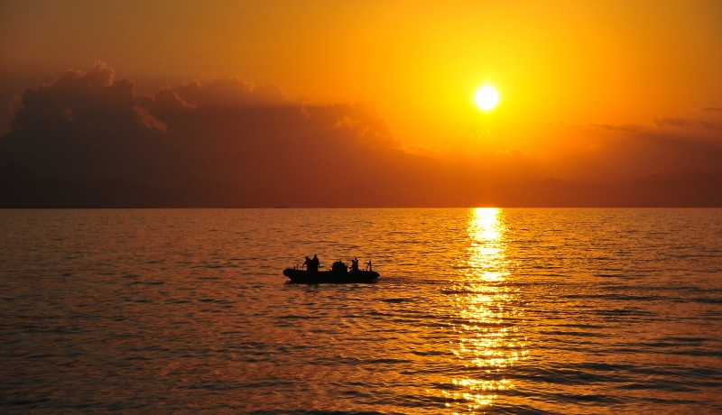 48. Golden Rays From the Sun Reflect Off the Caribbean Sea As Sailors, In A Rigid-Hull Inflatable Boat, Return To the U.S. Navy Guided-Missile Cruiser USS Normandy-CG-60 After An Initial Assessment of Petit-Trou-de-Nippes, January 23, 2010, Republique d'Haiti (Repiblik d' Ayiti) - Republic of Haiti.  Photo Credit: Mass Communication Specialist 3rd Class Samantha Robinett, Navy News Service - Eye on the Fleet (http://www.news.navy.mil/view_photos.asp, 100123-N-4774B-998), United States Navy (USN, http://www.navy.mil), United States Department of Defense (DoD, http://www.DefenseLink.mil or http://www.dod.gov), Government of the United States of America (USA).