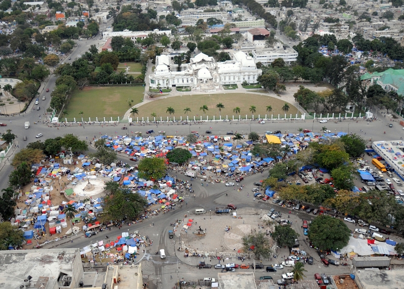 58. Earthquake Survivors Living In A Tent City In Front Of the Earthquake-Damaged Presidential Palace (National Palace), February 1, 2010, Port-au-Prince, Republique d'Haiti (Repiblik d' Ayiti) - Republic of Haiti. Photo Credit: Senior Chief Mass Communication Specialist Spike Call, United States Navy; Defense Visual Information (DVI, http://www.DefenseImagery.mil, 100201-N-5961C-002) and United States Navy (USN, http://www.navy.mil), United States Department of Defense (DoD, http://www.DefenseLink.mil or http://www.dod.gov), Government of the United States of America (USA).